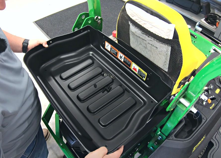 Close up showing how the storage tray attachment should be placed on the mounting brackets and how you should be able to see the stickers when standing looking at the tray from the rear