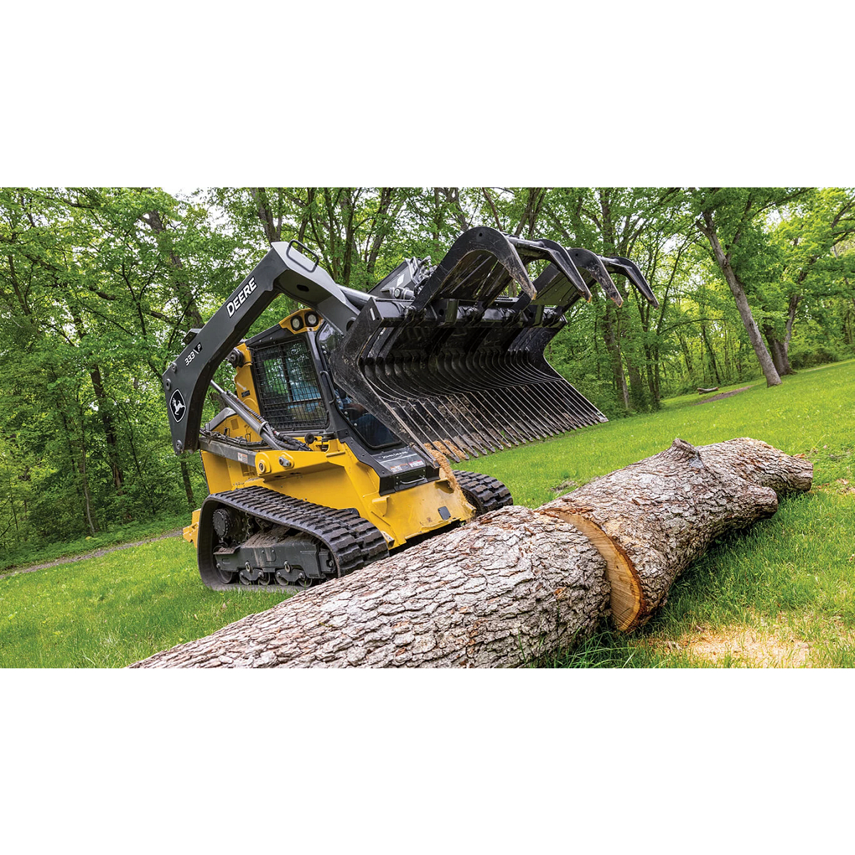 333 P-Tier compact track loader using John&amp;nbsp;Deere grapple attachment to move large log.