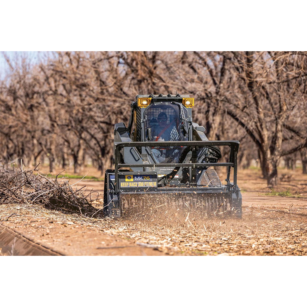 Front view of a 335 P-Tier compact track loader mulching brush with an MK76 mulching head