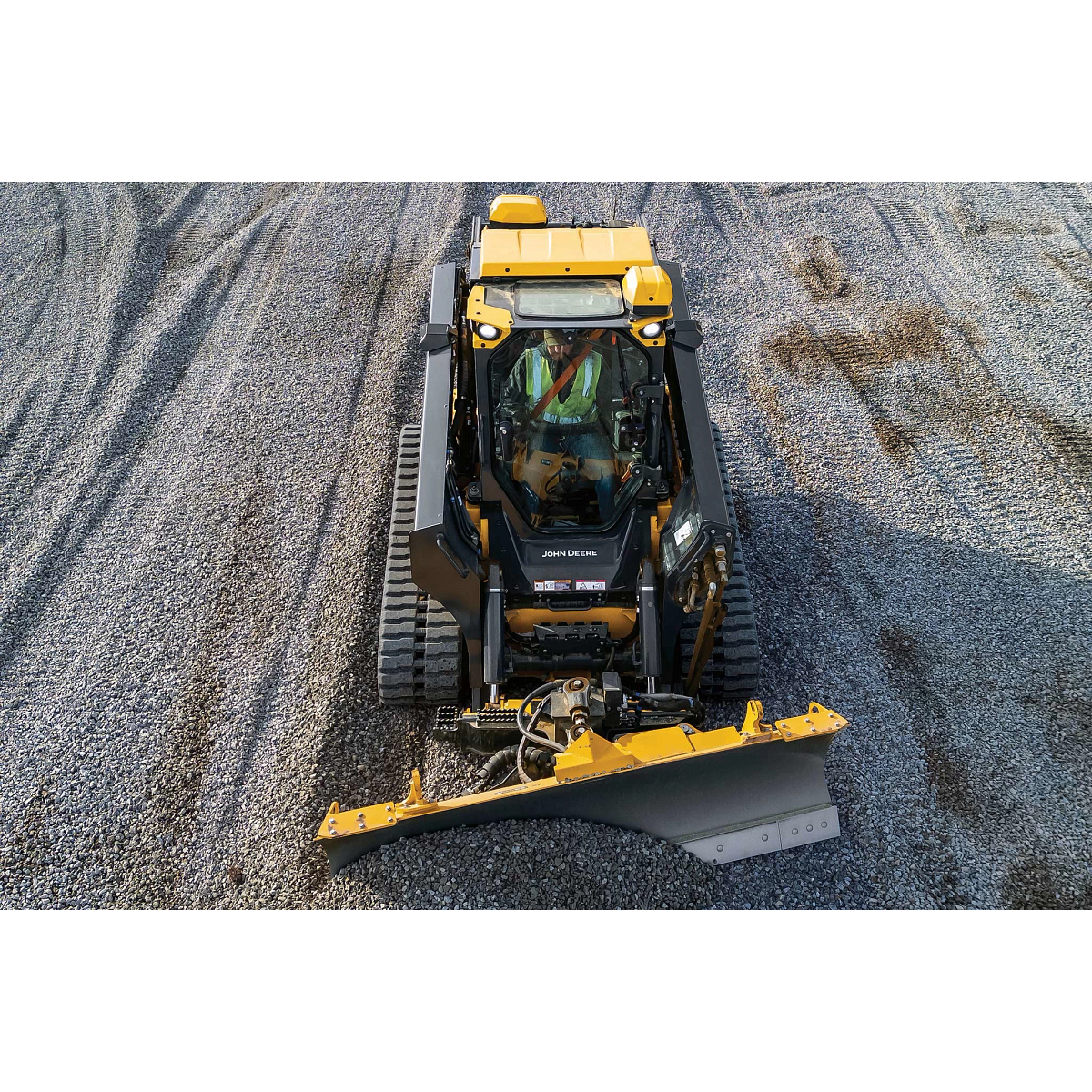 Top view of a 335 P-Tier compact track loader pushing gravel