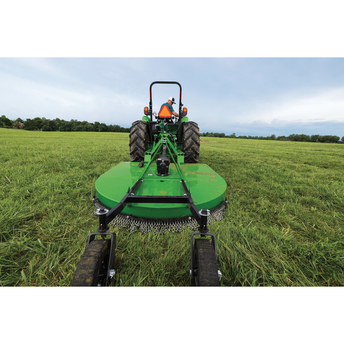 Rear field view of the RC2084 Rotary Cutter on 5 Series Tractor in a grassy field