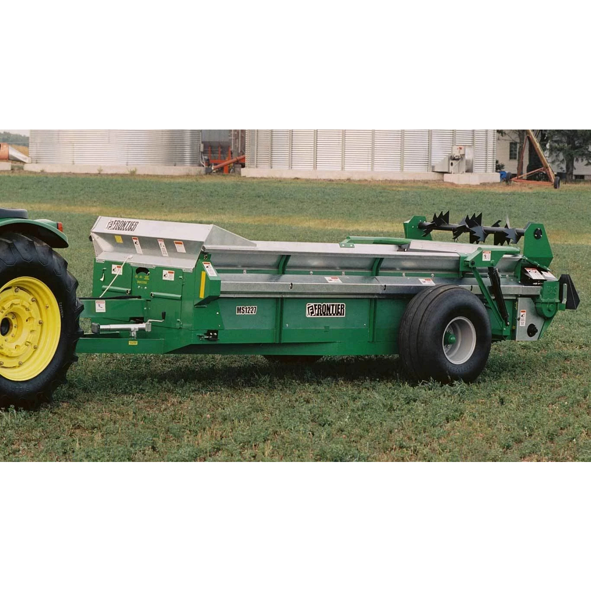 MS12 Series Manure Spreader on grass with bins behind it