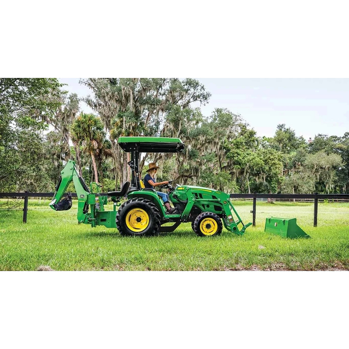 3025E 3 Series Compact Tractors with a farmer driving a tractor with a loader attached to it