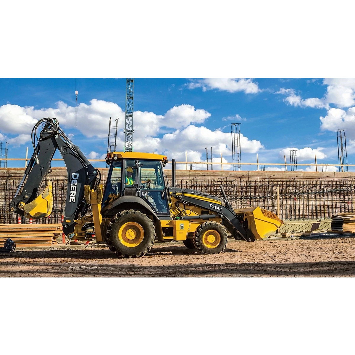 410 P-Tier Backhoe on a jobsite with a bucket full of dirt