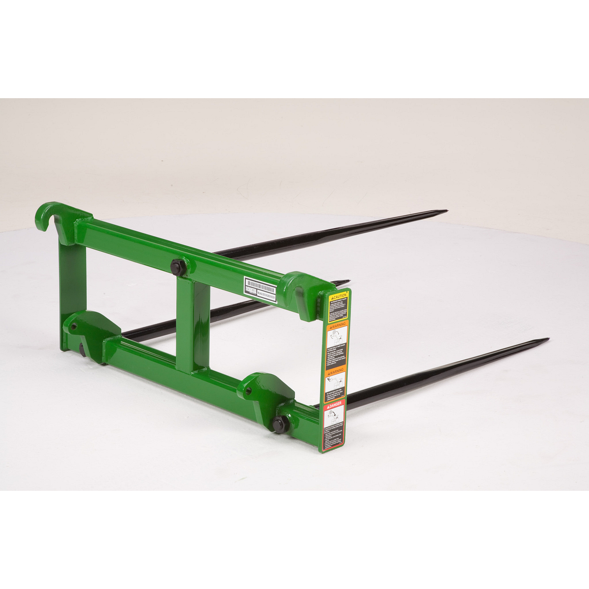 Pallet fork attachment showing the mounting hooks from a front angle with safety labels visible on the frame