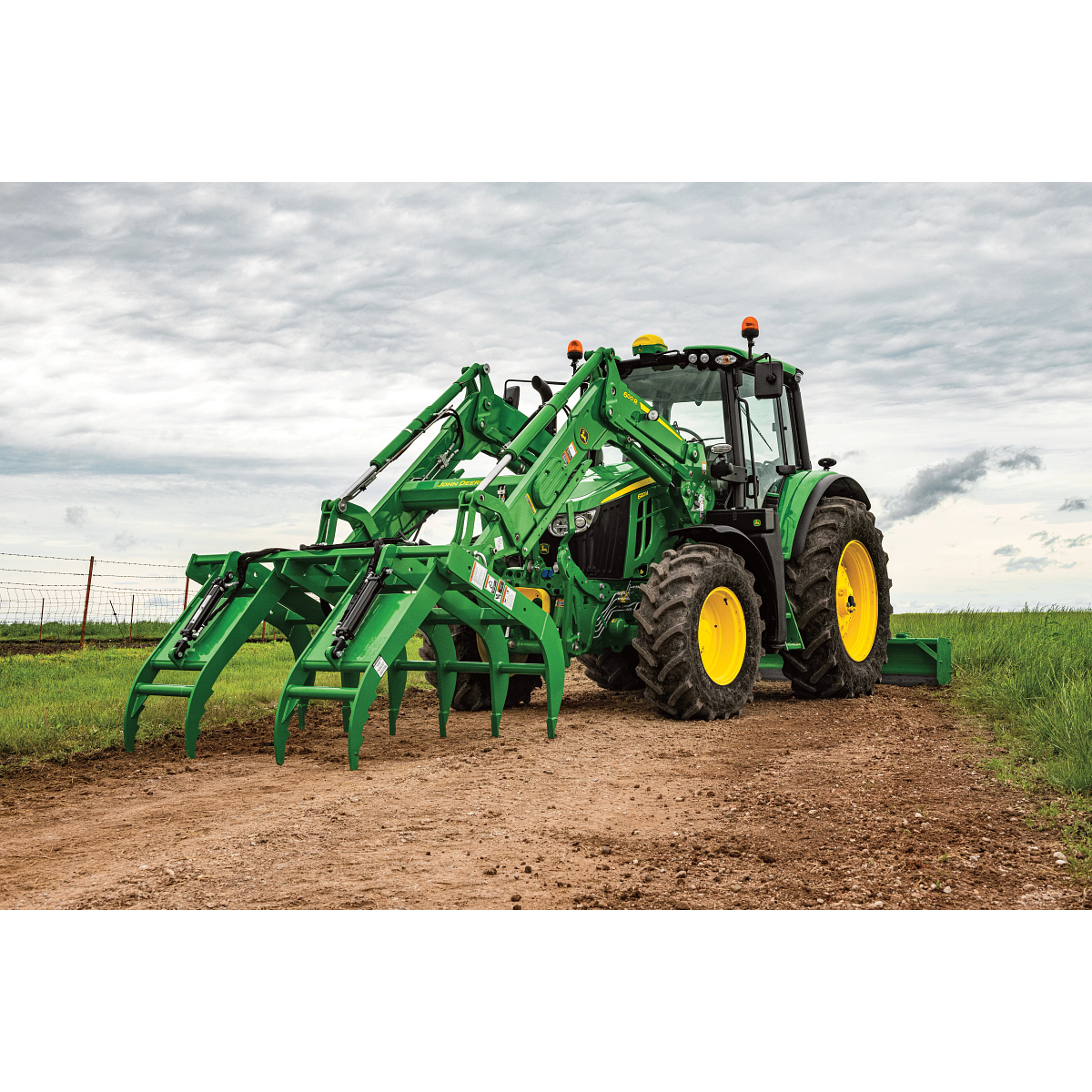 Field view of AV20G Root Grapple and RB2308 Rear Blade on a 6120M Tractor