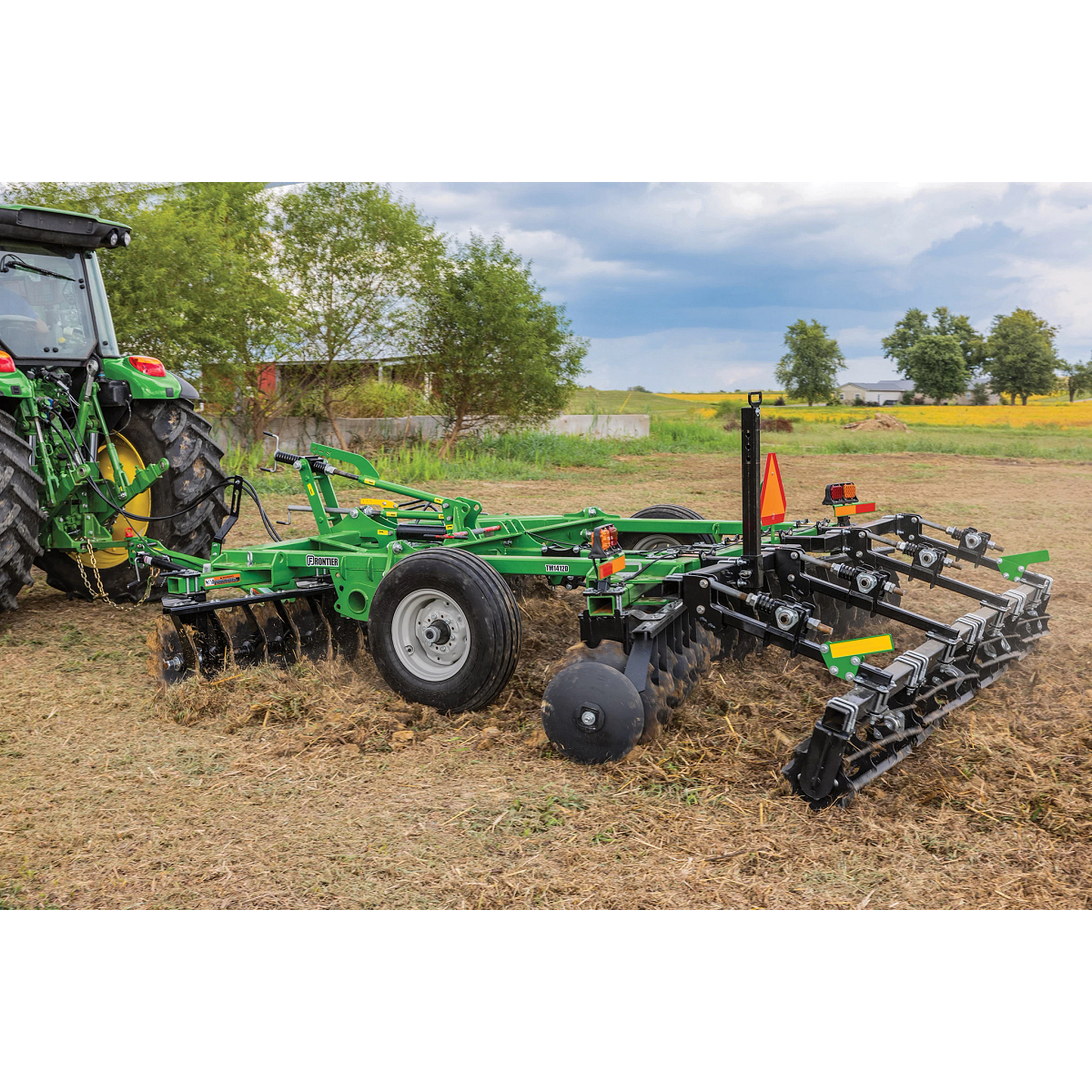 Tractor pulls a TM14 Series Frontier Tandem Disk Harrow in the field.