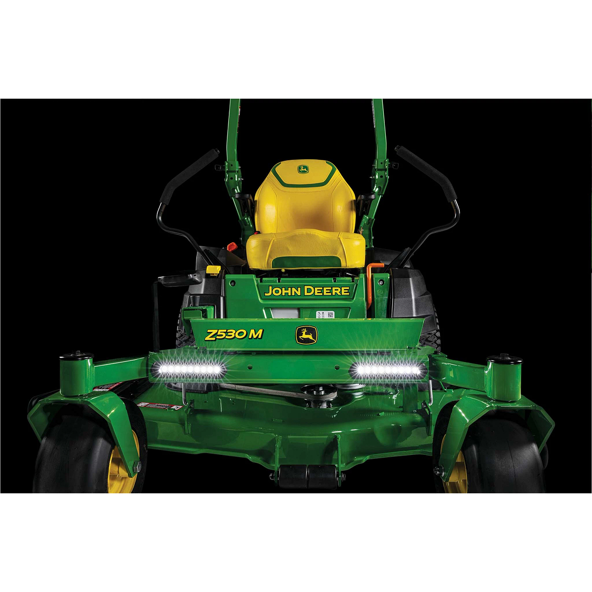 A dramatic close-up front shot of the yellow seat and LED lights on a Z530M zero-turn mower with a black background.