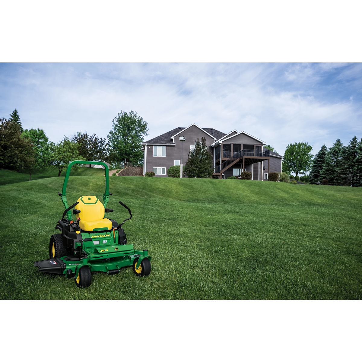 A Z515E zero-turn mower with a yellow seat rests on a well-kept lawn.