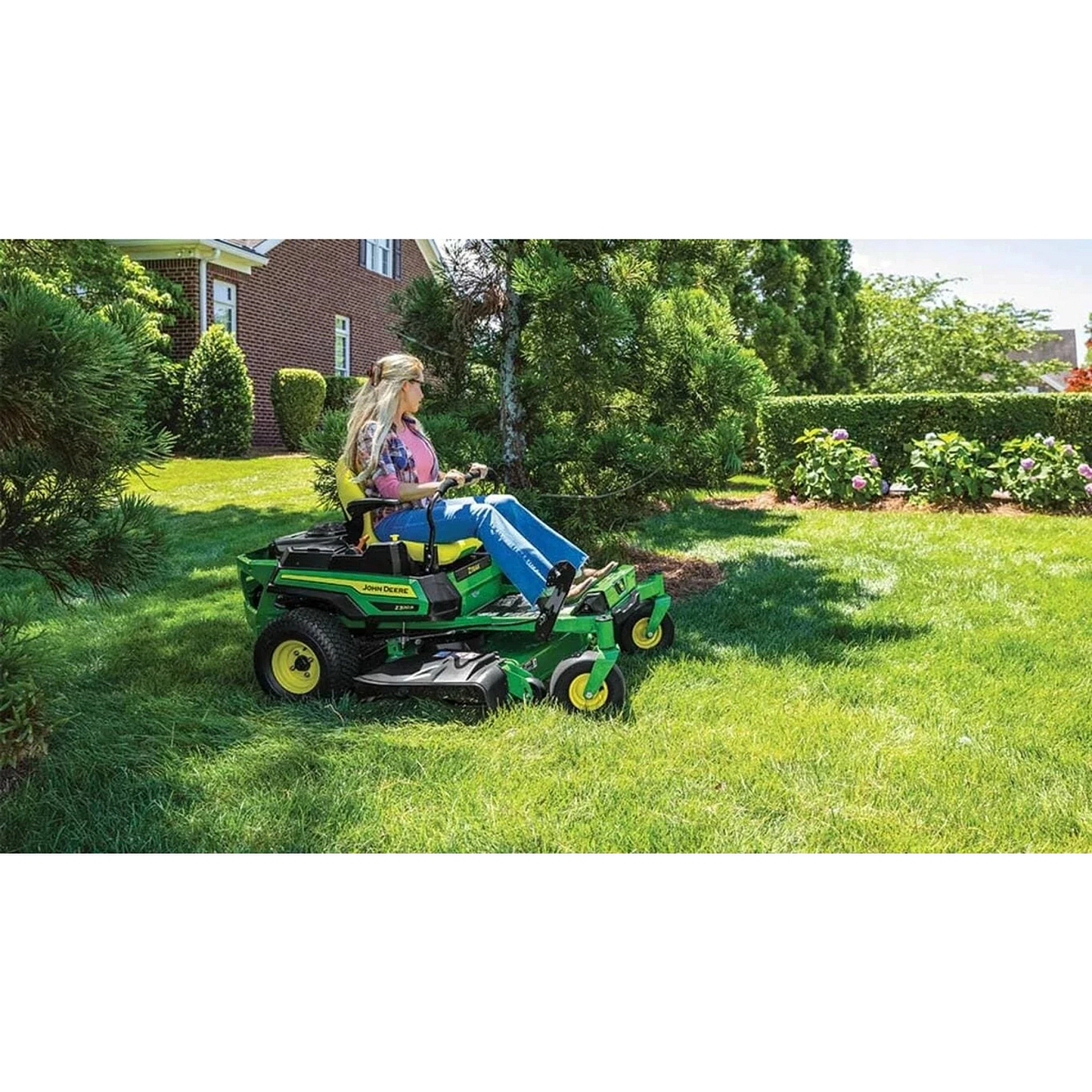 Homeowner mowing grass with a Z320R ZTrak Mower between plants and trees