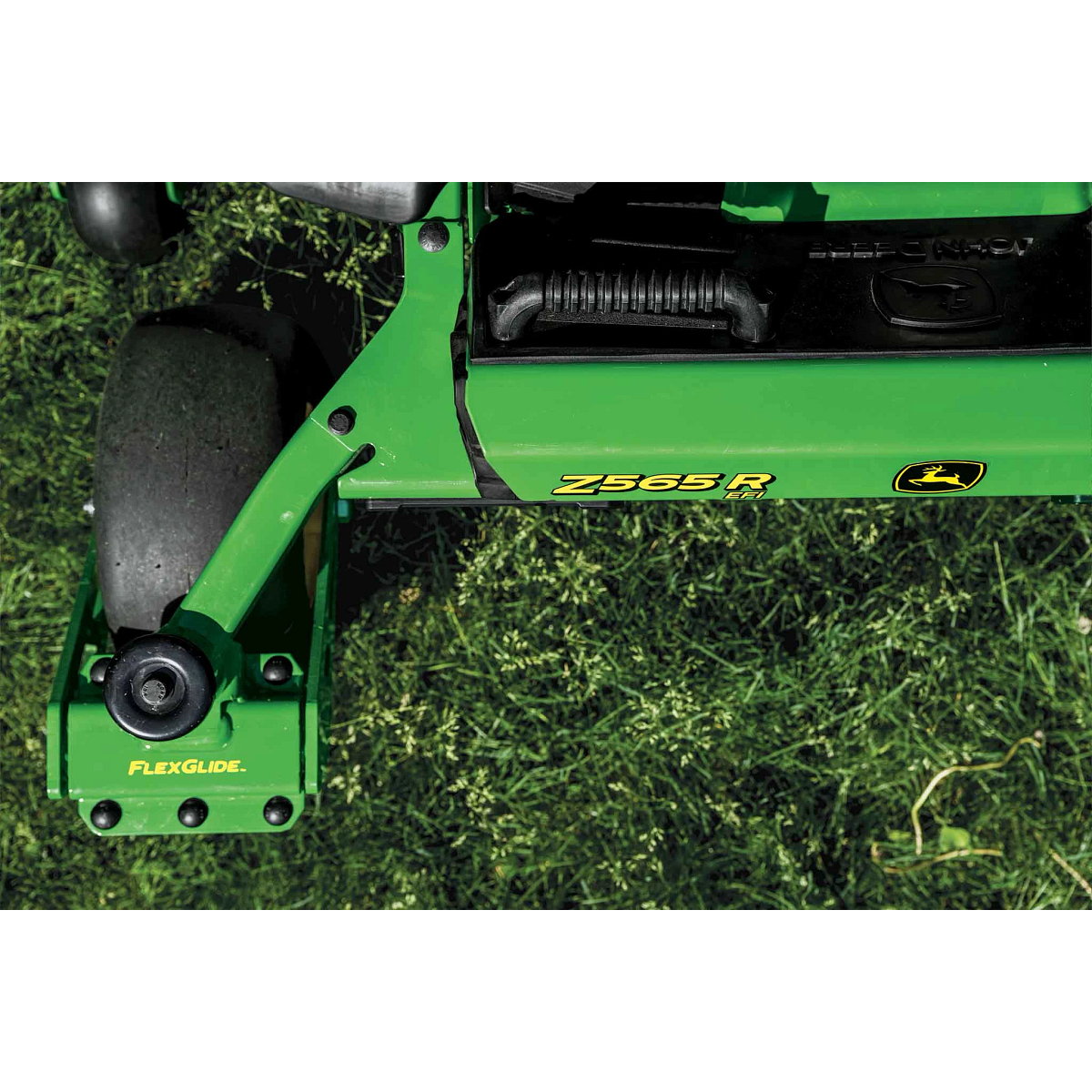 Close-up shot of the Z565R and FlexGlide logos on a zero-turn mower over grass.