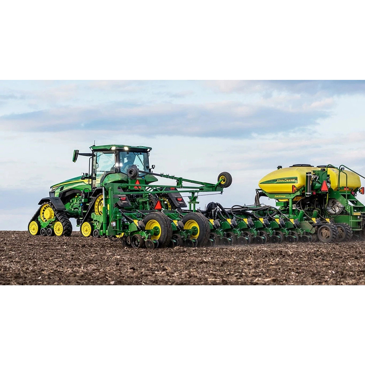 8RX 310 Four-Track Tractor with a seeder in a field