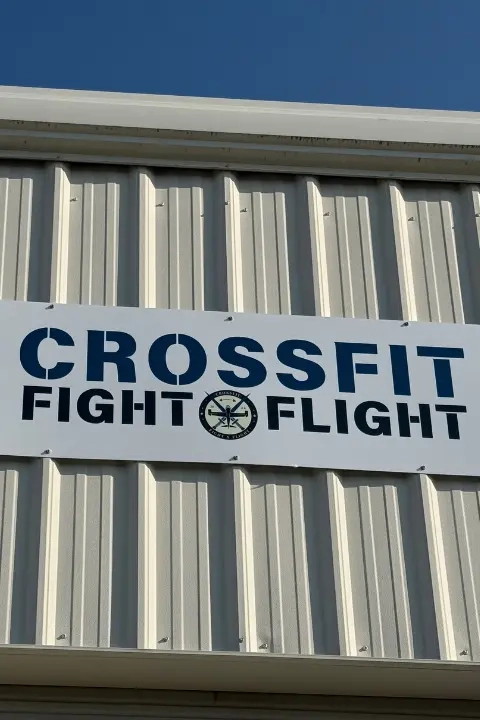 Exterior sign displaying the CrossFit Fight x Flight logo on the gym building.