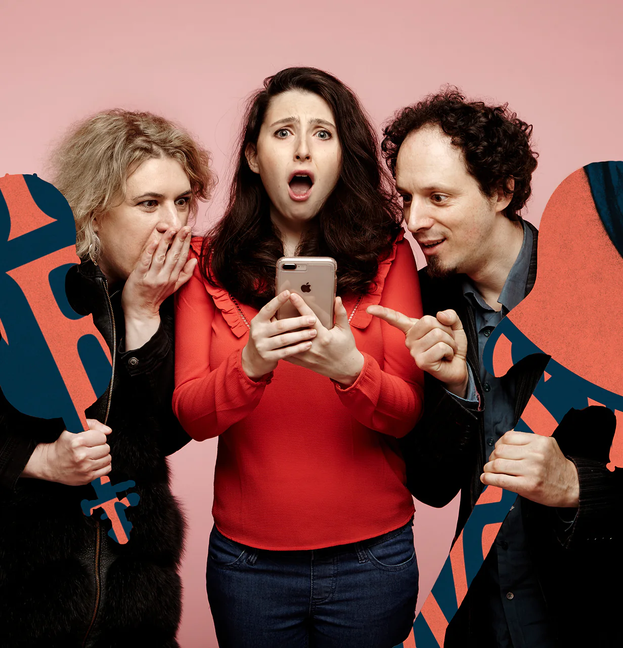 Three people, one shocked looking at a phone, another whispering, and the third pointing, holding large cutouts.