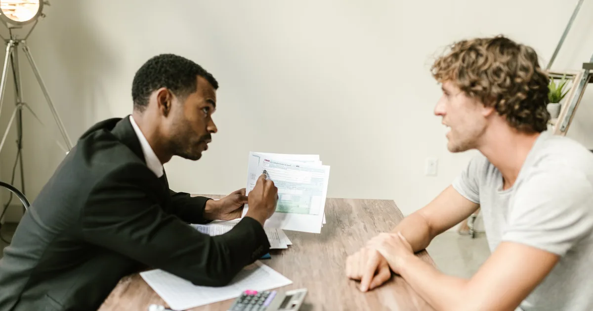 An advisor walking a client through documentation at a desk