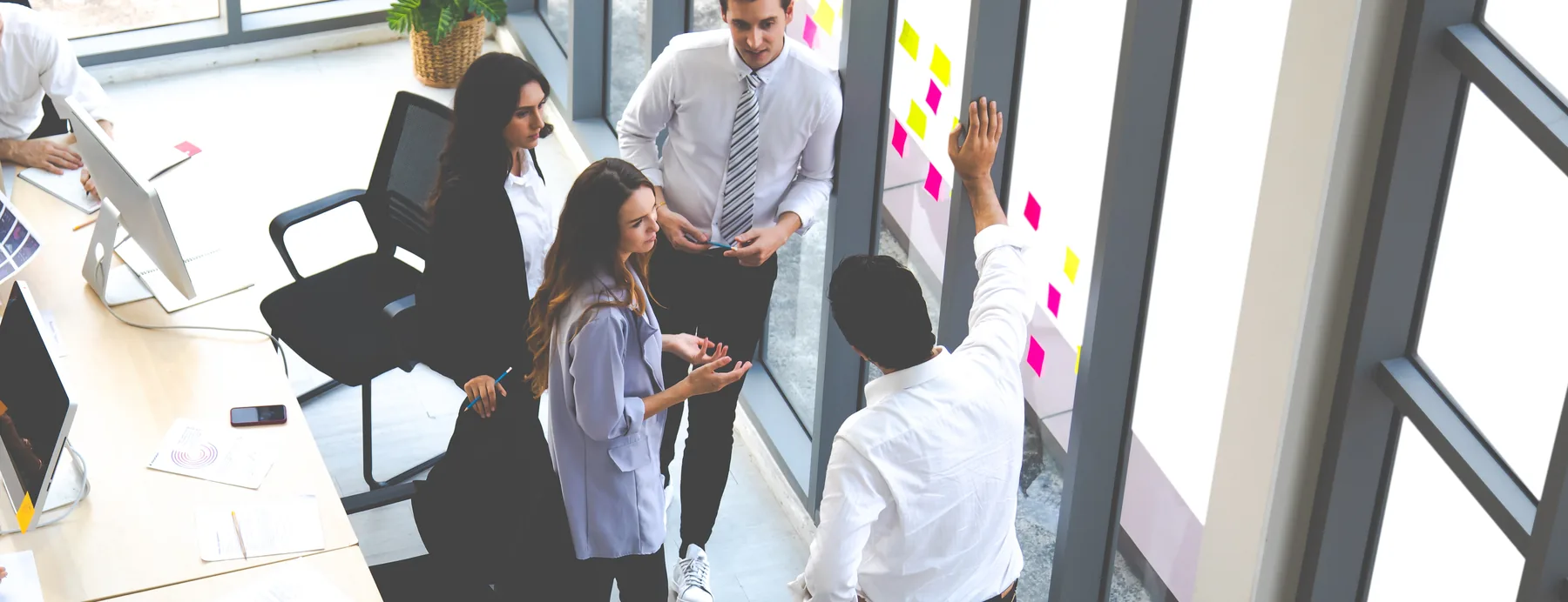 A team working through a session together in a glass-walled office