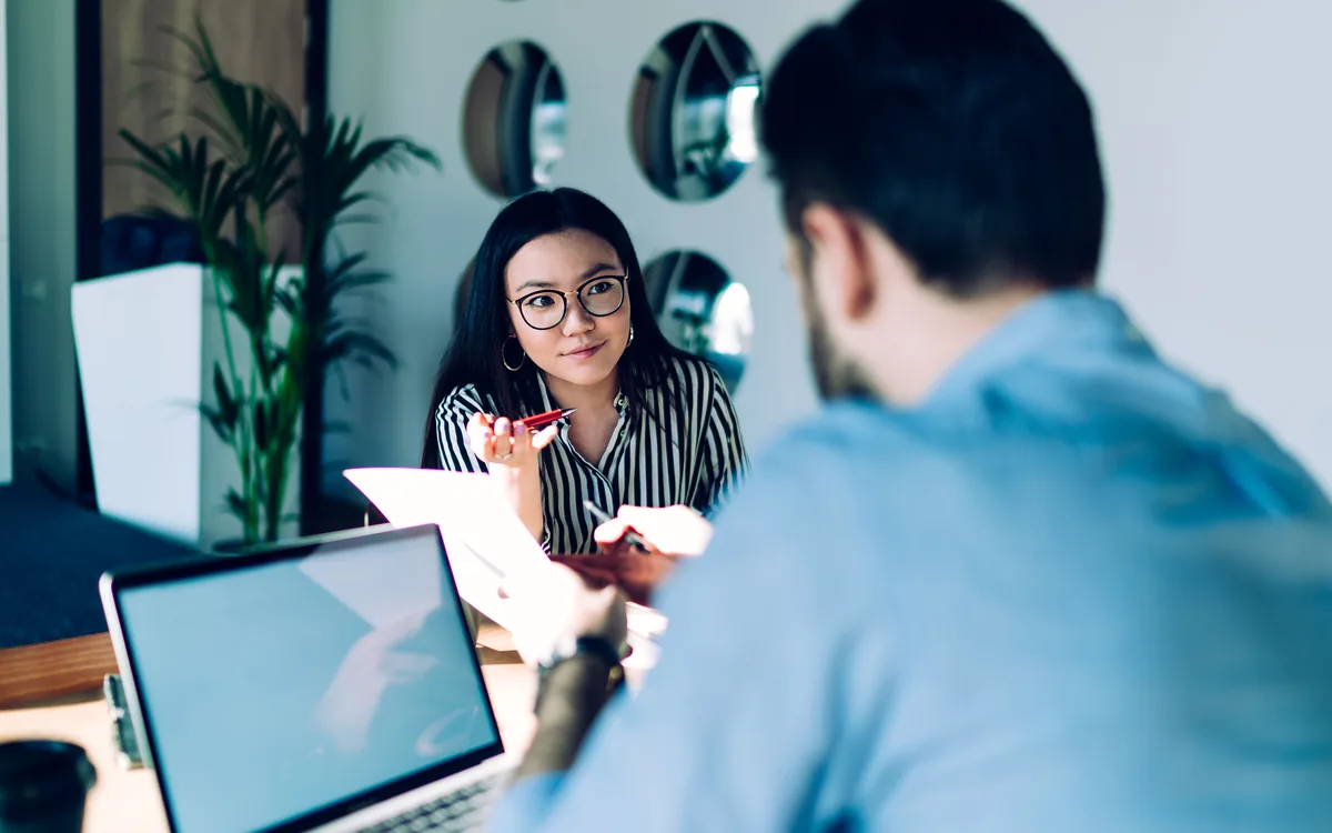 A consultant explaining a document across the table to a colleague