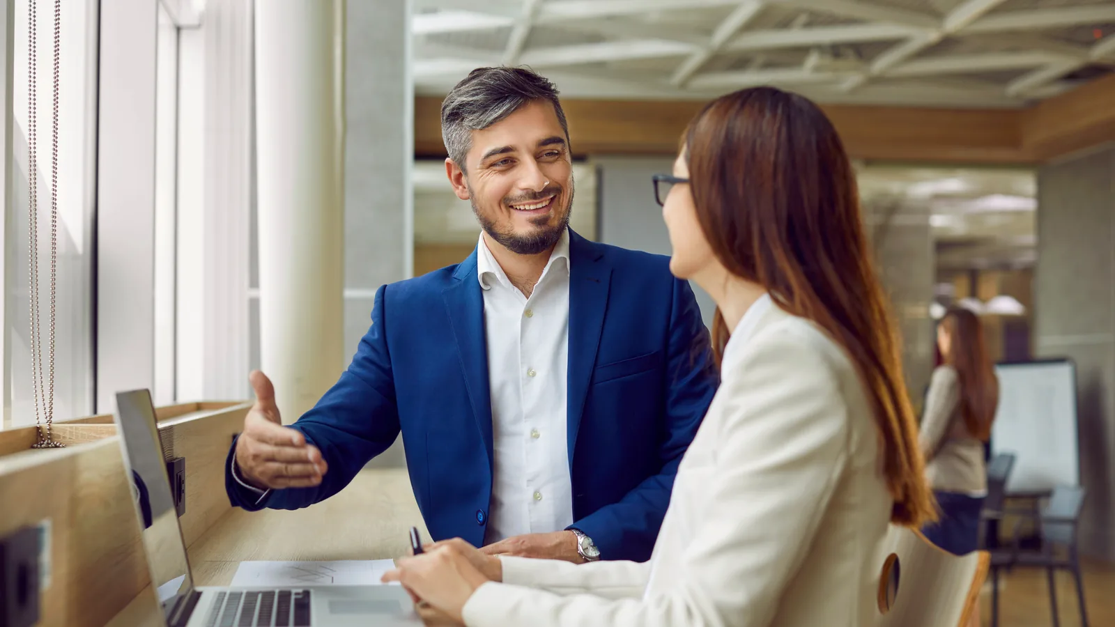 A security advisor in conversation with a client across a desk