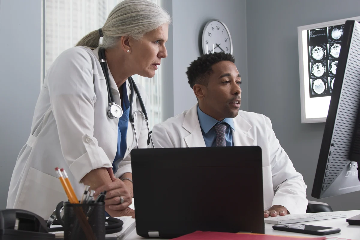 Two colleagues reviewing information together on a screen in a clinical office