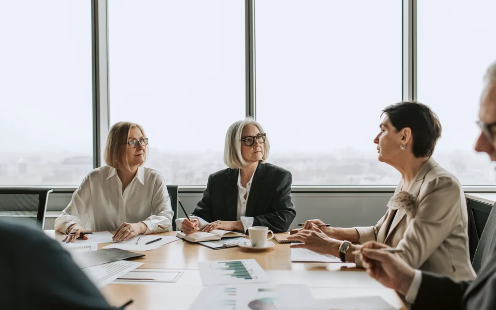 Advisers walking a leadership team through findings and charts around a table