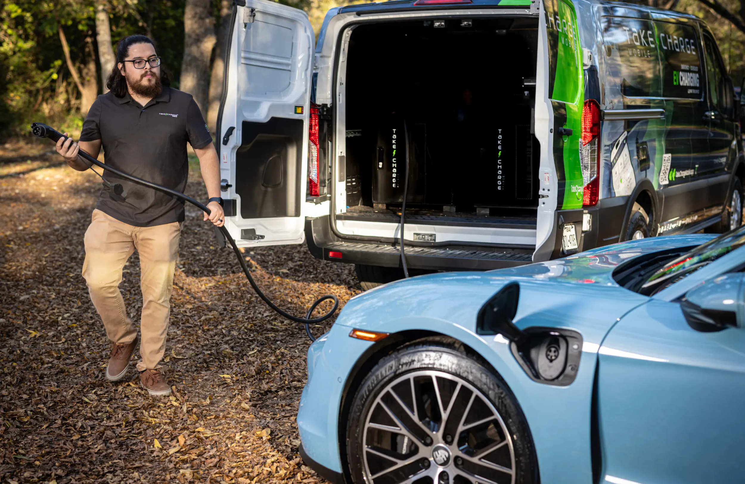 Take Charge technician connecting a mobile charger to a stranded EV