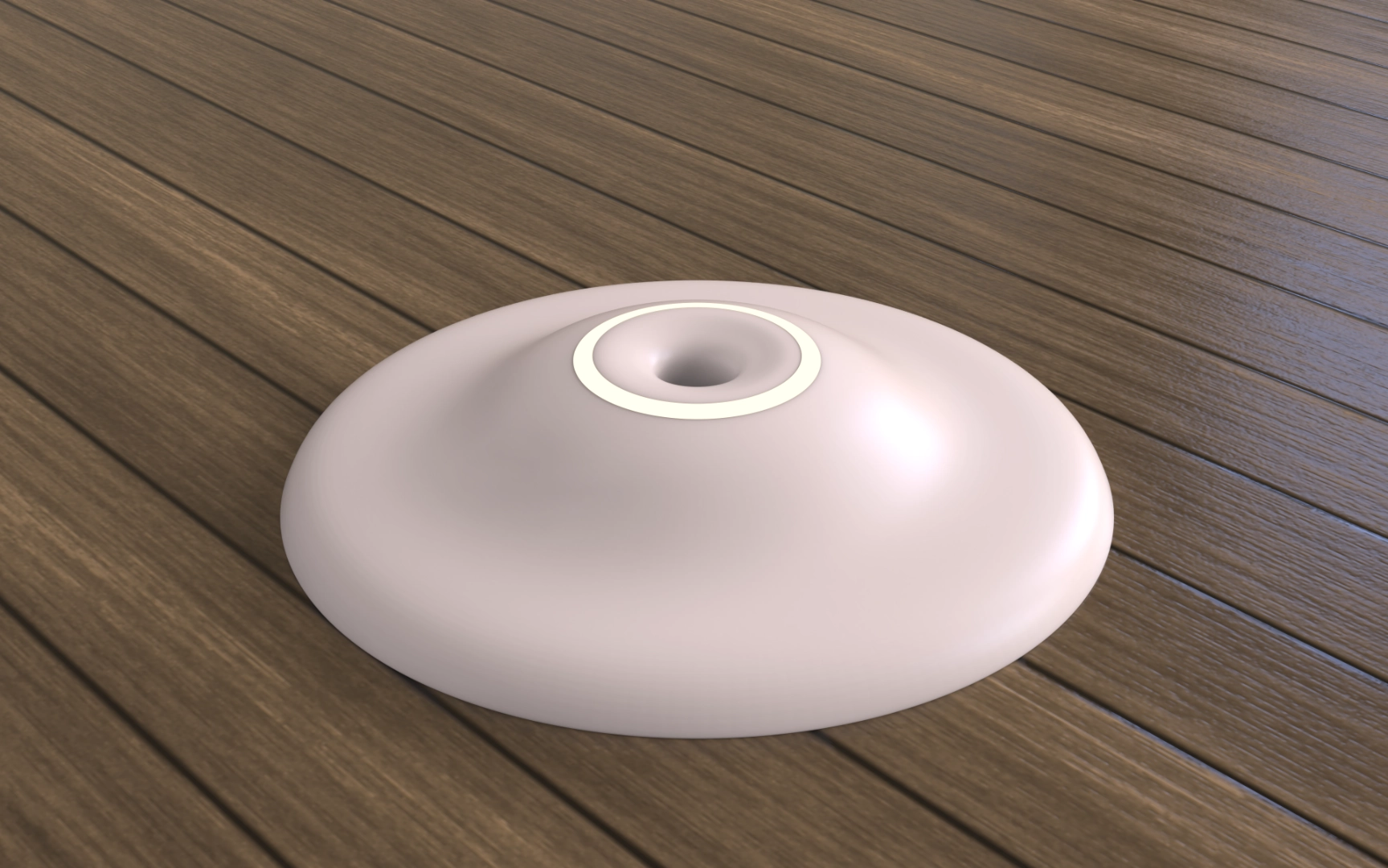 Smooth, rounded white object with a central hole, resting on a wooden surface.