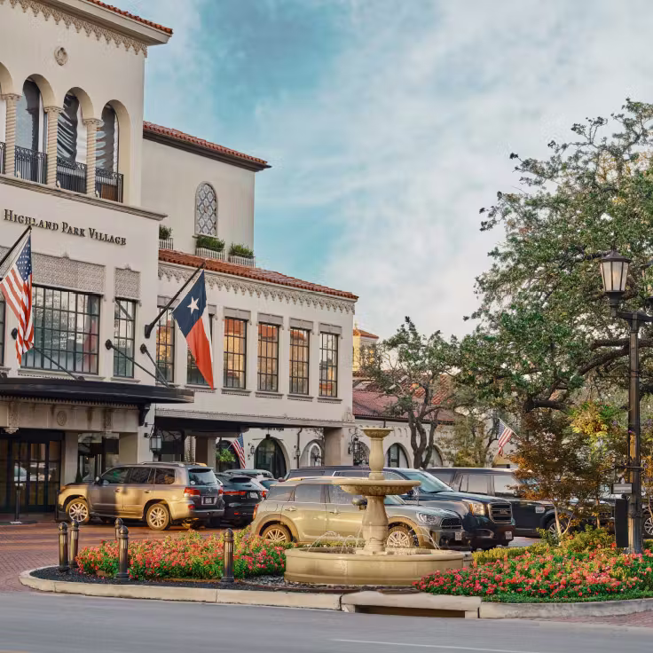 Shops and a stone fountain with flowers at Highland Park Village.