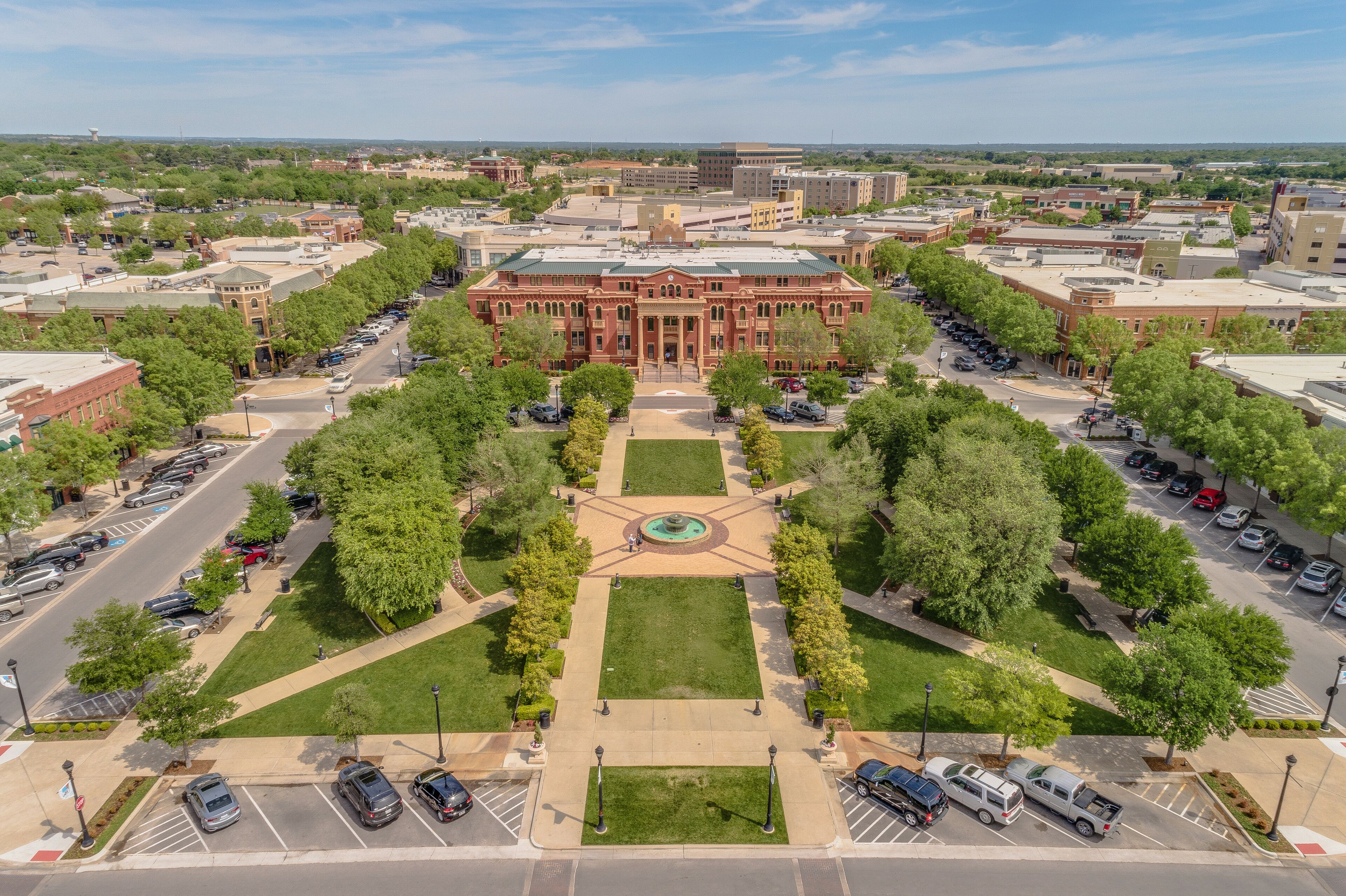 Aerial view of Southlake Town Square with a brick town hall, green lawns, and shaded walkways.