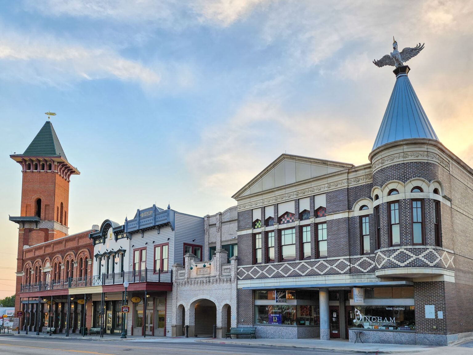 Old brick storefronts along Main Street in Grapevine with a tall tower on the corner.