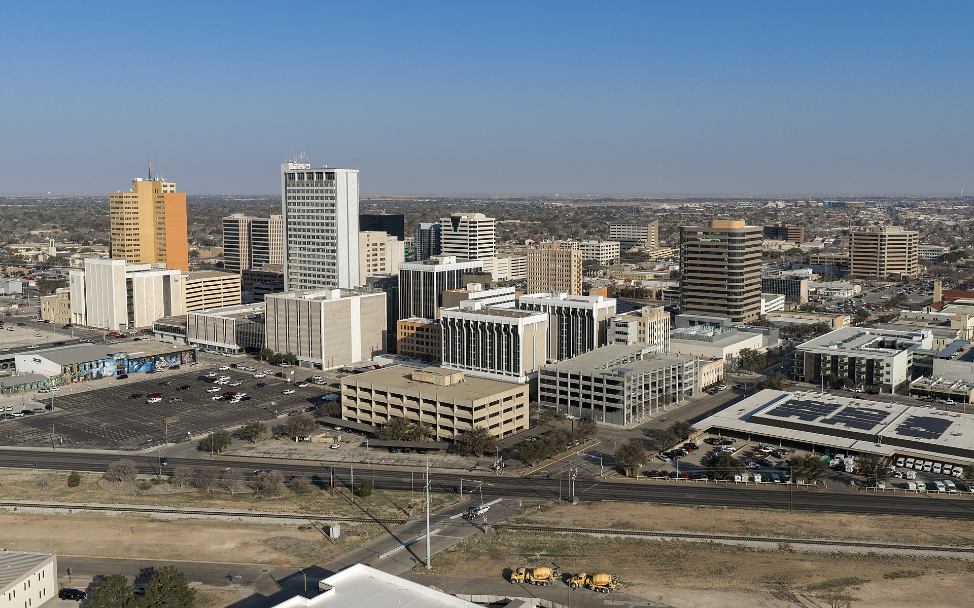 Downtown Midland seen from above with office towers, parking lots, and flat land beyond.