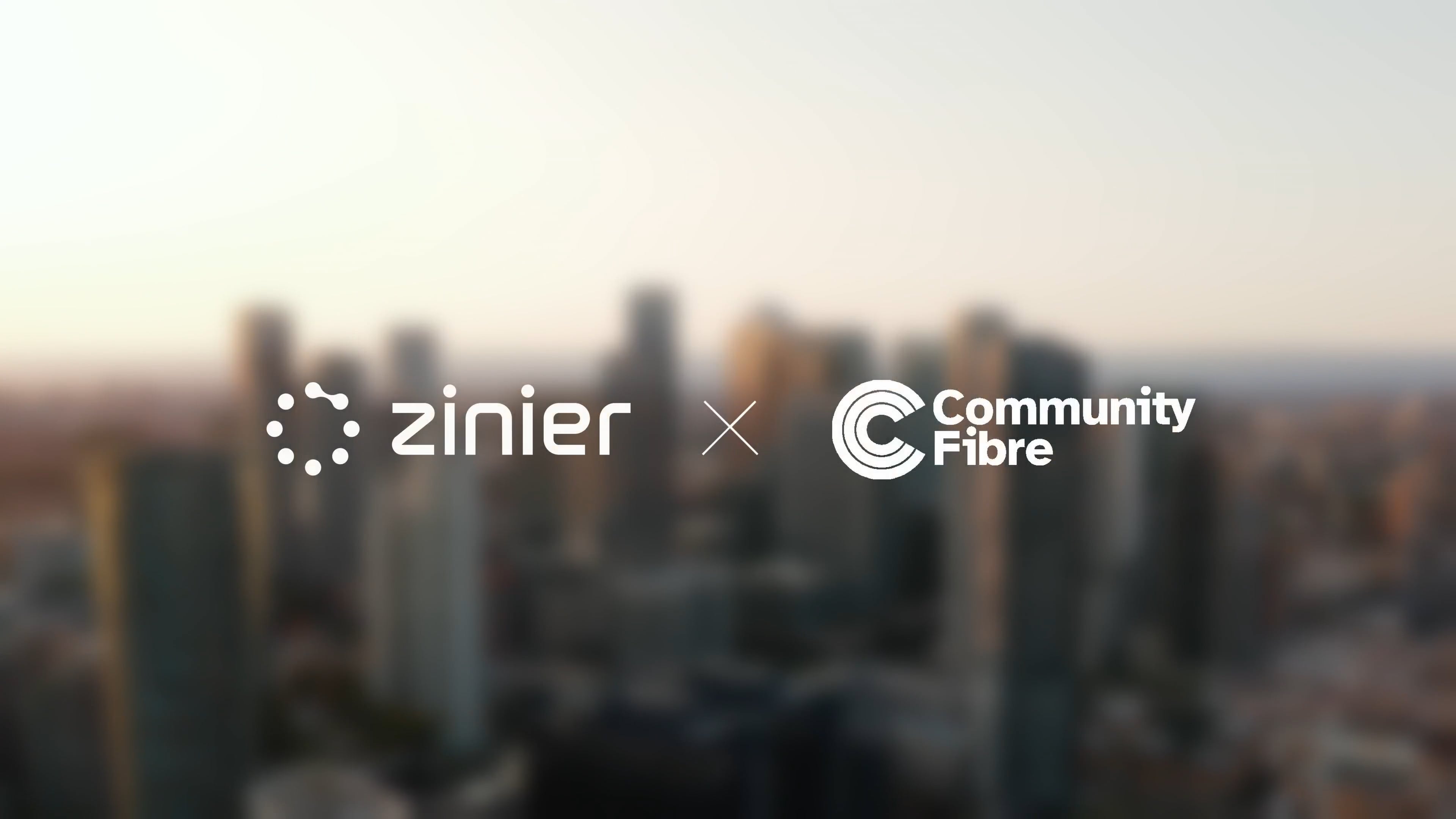 Zinier- und Community Fibre-Logos vor einer unscharfen Skyline