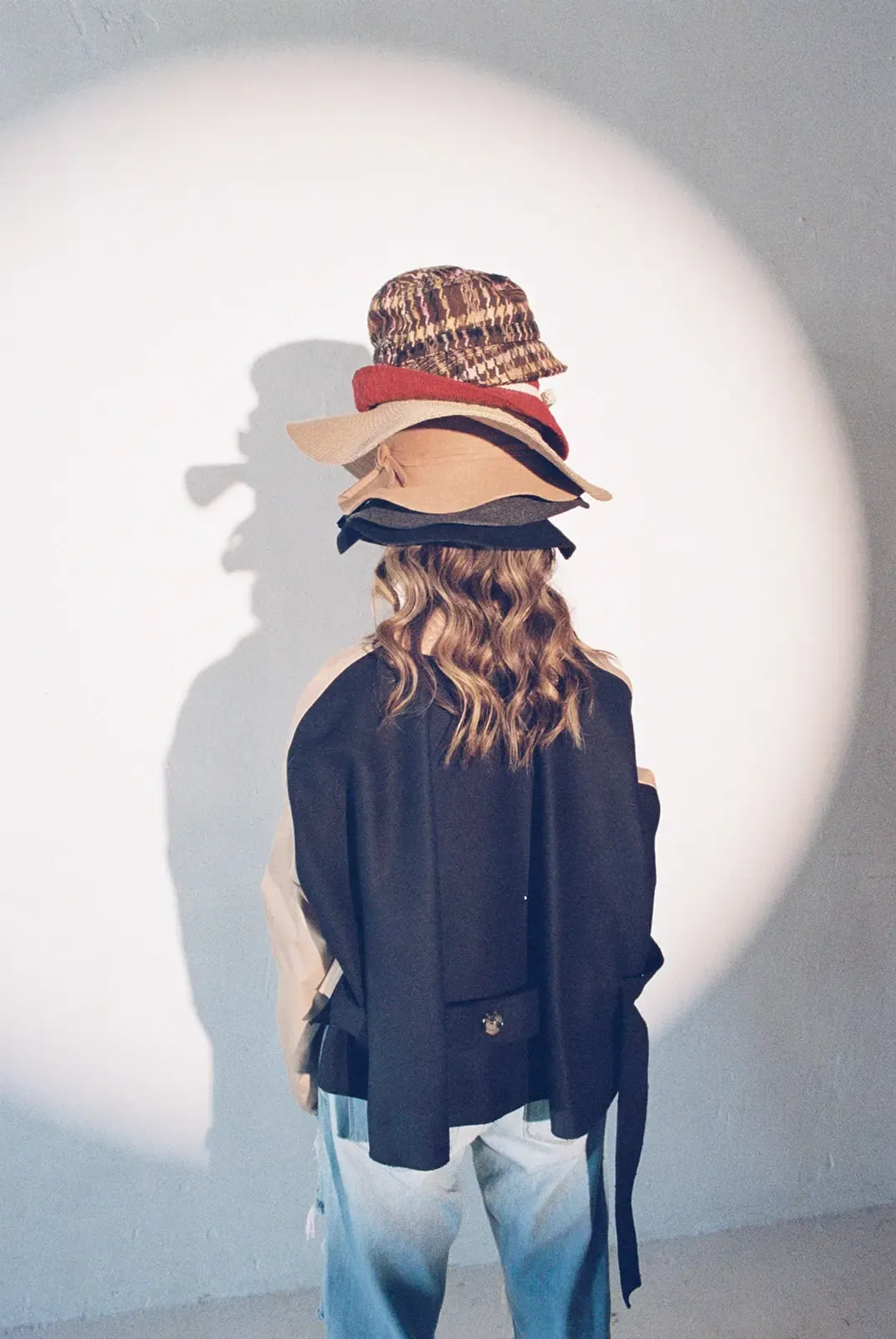 A real estate agent balancing a stack of hats, one for every role in a busy day