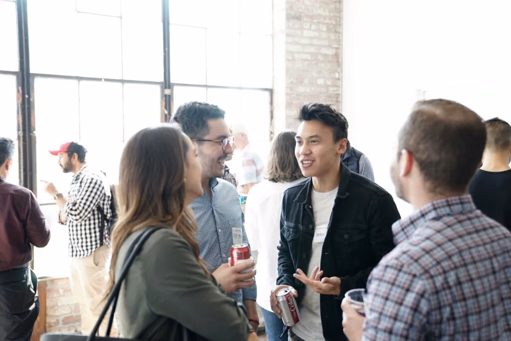 Social college events - Group of people having a conversation in a bright room with soft drinks