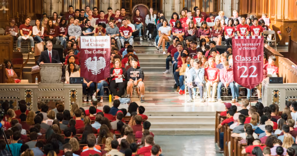 College events at the University of Chicago. A large crowd in a fancy hall with people wearing brown and holding banners