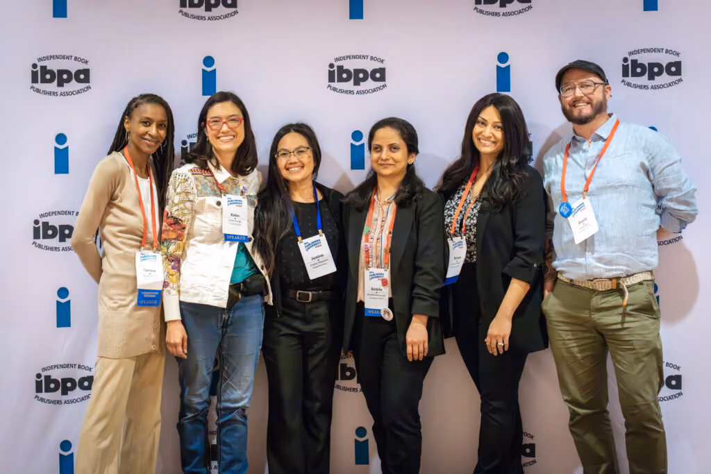 Event managemetn attendees at IBPA conference in front of branded background