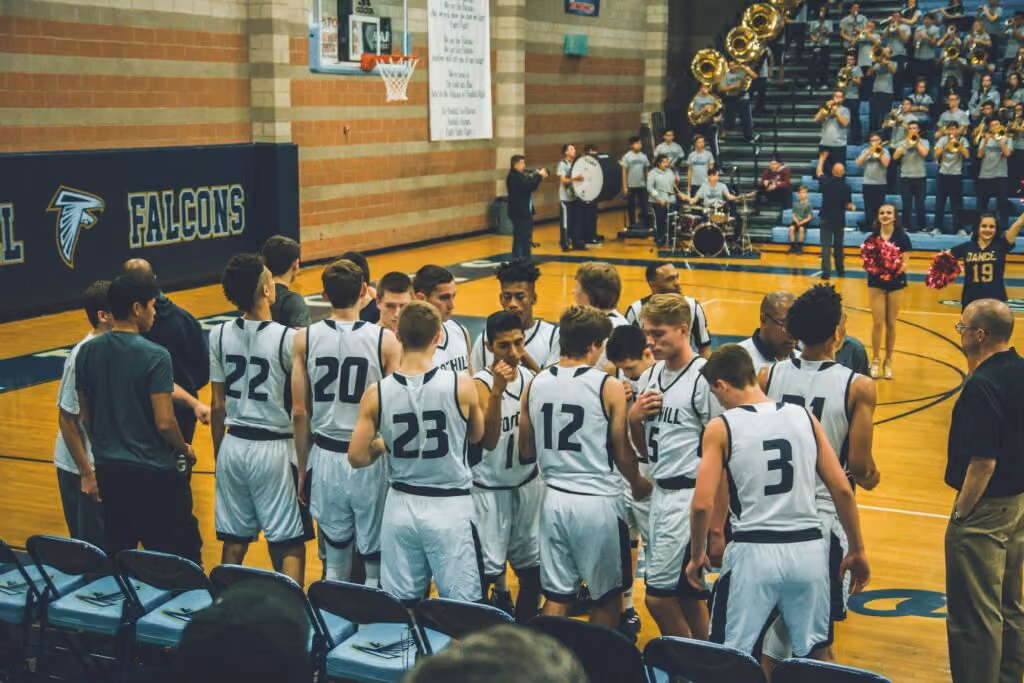 K-12 schools basketball team taking a time-out while band plays in the background