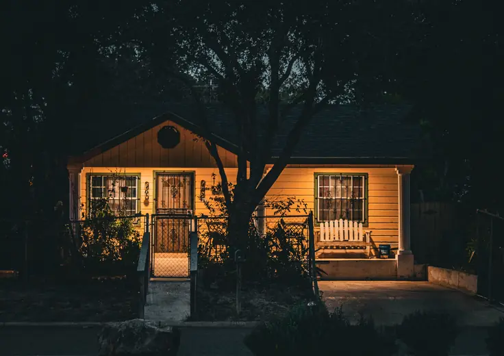 Small rental house lit from inside at night
