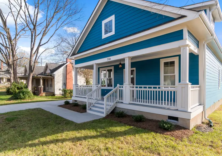 Blue single-family rental home with a white front porch and landscaped yard.