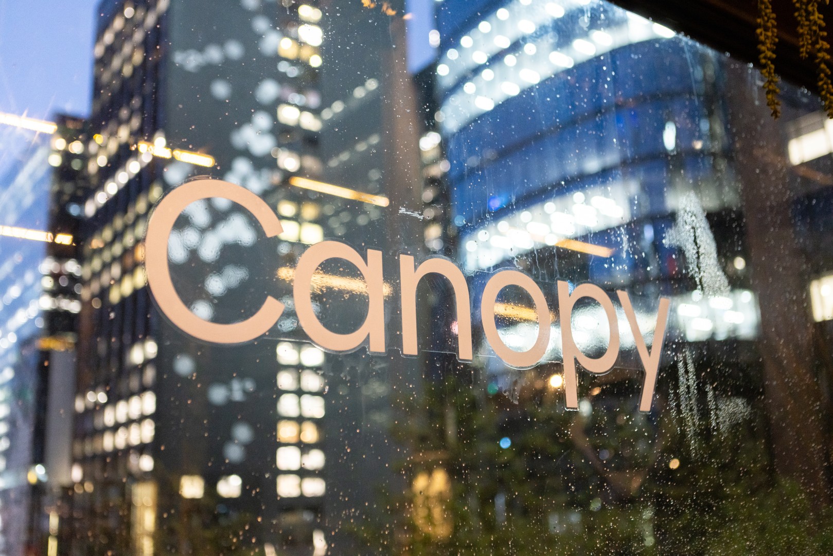 Canopy logo on the window at Bomba Rooftop Bar with the Melbourne skyline behind