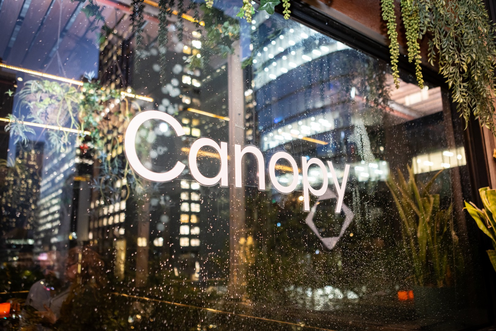 Canopy logo on a rain-covered window at Bomba Rooftop Bar, Melbourne