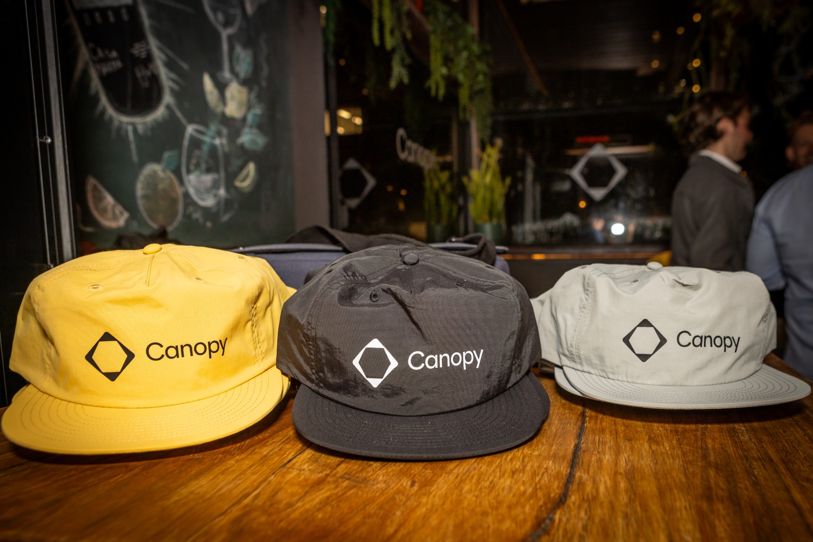 Yellow, black and grey Canopy caps on a table at the Canopy launch