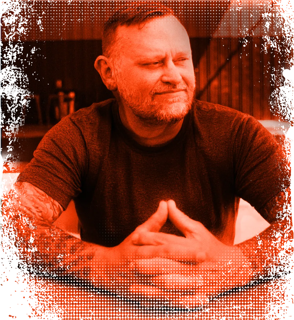 Ronnie Garver, red duotone portrait, hands steepled, glancing to the side