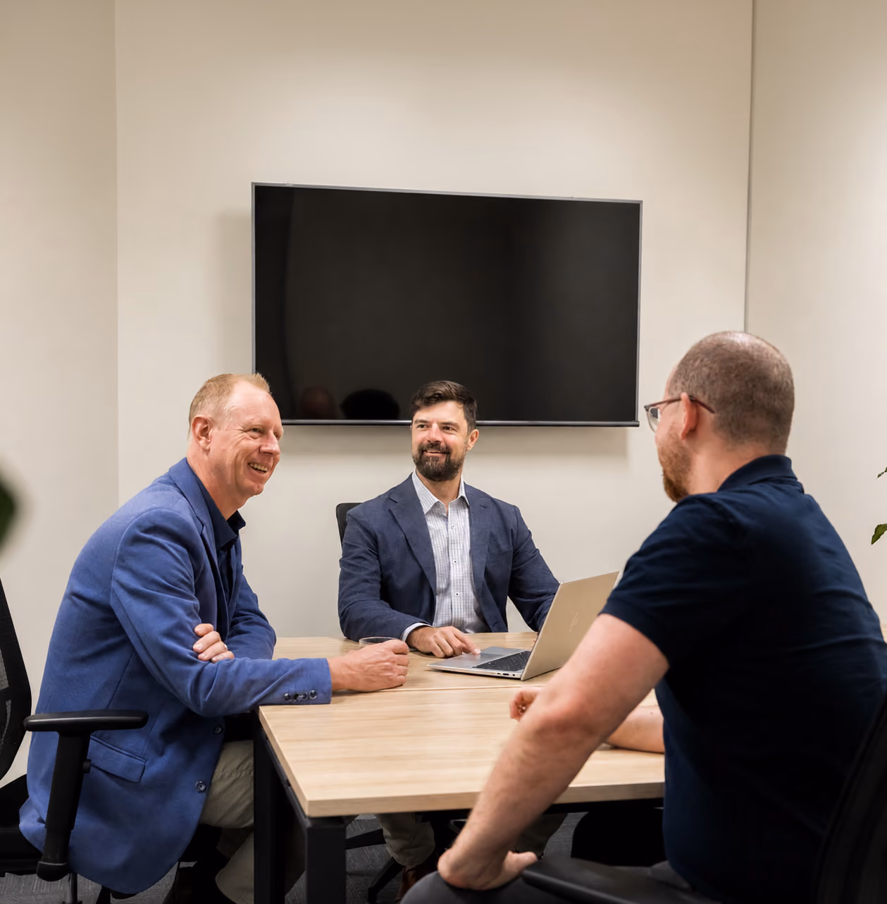 Three team members discussing cyber security in a meeting room.