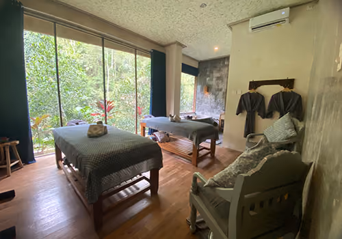 Two treatment beds inside the Jamu Spa room, facing a window onto the jungle