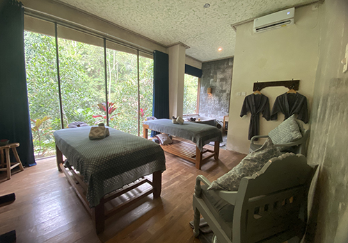 Two treatment beds inside the Jamu Spa room, facing a window onto the jungle