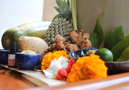Fresh turmeric, ginger, papaya, and marigold laid out for a Balinese healing ritual