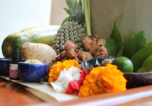 Fresh turmeric, ginger, papaya, and marigold laid out for a Balinese healing ritual