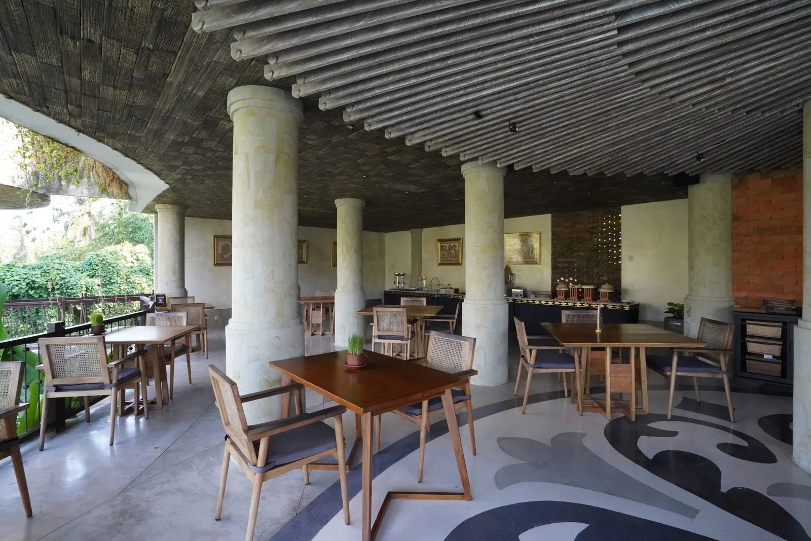 Open-air dining at T’dung Restaurant with pool and jungle beyond the tables