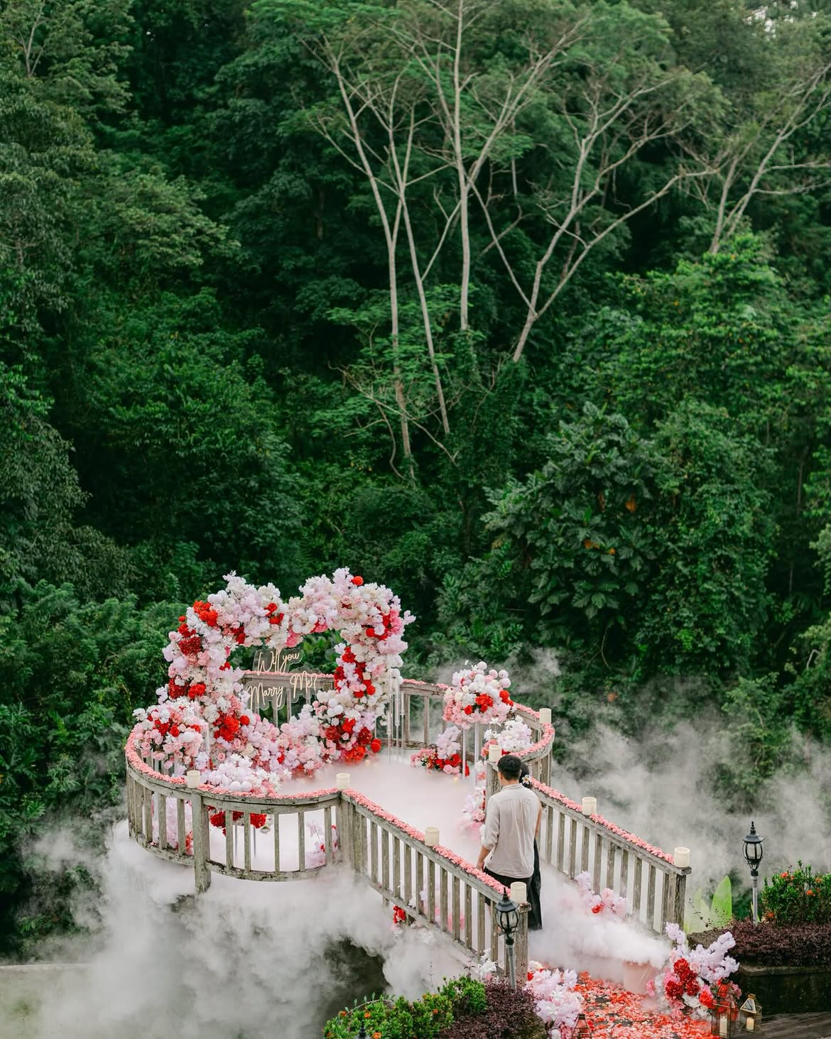A bride and groom standing together on the bridge in front of the Mantra Pavilion