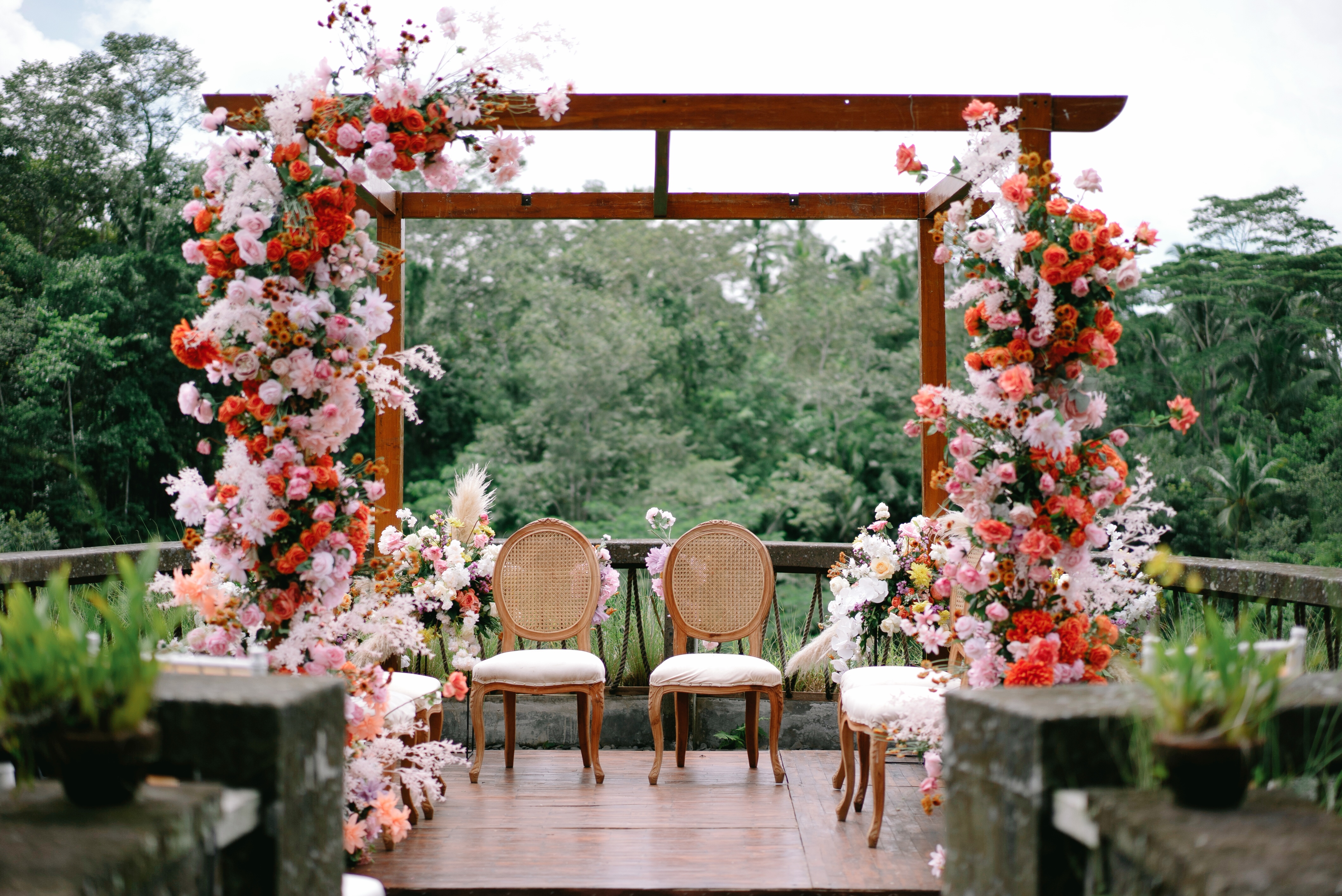 The bamboo Mantra Pavilion set for a ceremony, with white chairs and floral arrangements lining the aisle